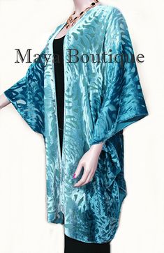 "DESCRIPTION Maya Matazaro Teal Ombre Camellia Burnout Velvet Caftan Kimono Jacket Hand Dyed & Made in USA Elegant kimono in the caftan style Teal ombre Color A true wearable art! Burnout velvet Camellia design Rayon Blend Free size - Good for Regular sizes & Plus Sizes too 76\" Wingspan Open front 36\" Long Please note that each caftan is individually hand dyed by Maya personally, so colors will vary slightly from caftan to caftan As with all hand dyed fabrics each one is unique, but yo Teal Velvet Duster, Teal Velvet Robe, Casual Tie-dye Kimono For The Beach, Velvet Burnout Kimono, Bohemian Long Tie-dye Kimono, Elegant Kimono, Teal Ombre, Hand Dyed Fabric, Ombre Color