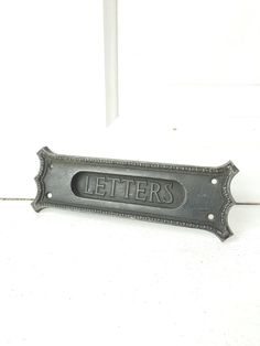 a metal sign that says letters on the side of a white door with black lettering