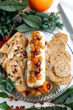 a plate with bread, crackers and fruit on it next to holly wreaths