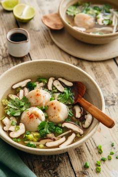 a bowl of soup with scallops, mushrooms and broccoli in it