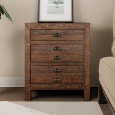 a wooden dresser with three drawers next to a couch