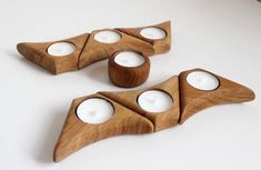 three wooden candle holders with white candles in them