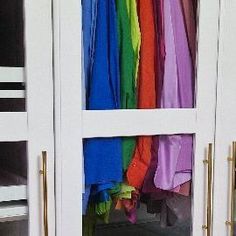 the closet is filled with many different colored clothes