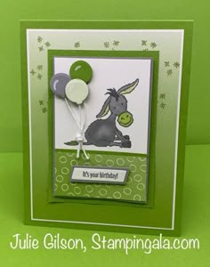 a birthday card with a balloon and a donkey on it's side, in front of a green background