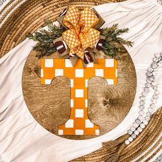 the letter t is decorated with footballs and greenery