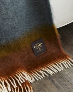 a brown and blue blanket sitting on top of a wooden floor