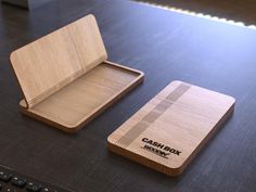 two wooden business cards sitting on top of a desk next to a computer mouse and keyboard