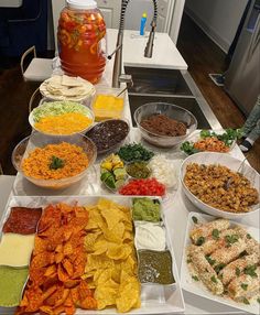 a table filled with lots of different types of food on plates and bowls next to each other