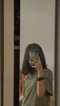 a woman taking a selfie in front of a mirror