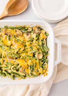 a casserole dish filled with green beans, mushrooms and cheesy sauce