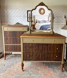 a bedroom with a bed, dresser and mirror on it's side table in front of a patterned rug