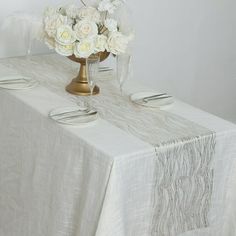 a table topped with white flowers and plates