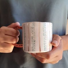 a person holding a coffee cup in their hands