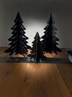 three metal trees sitting on top of a wooden table