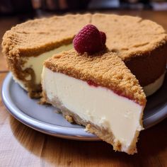 a piece of cheesecake with a raspberry on top