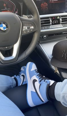 a person sitting in the driver's seat of a car with their feet on the steering wheel