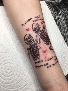 a couple of skeleton tattoos on the arm with words written in it and hearts around them