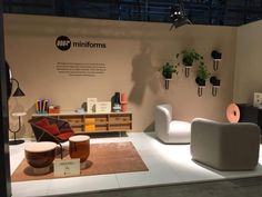 a room with furniture and plants on display at the showroom for mintforms