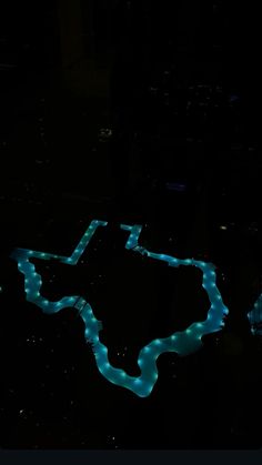 an aerial view of a river in the dark with blue lights on it's sides