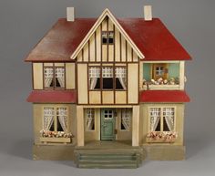 a doll house with windows and curtains on the top floor is shown in front of a white background