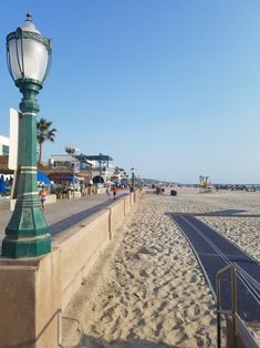 a street light sitting on the side of a beach next to a sandy shore line