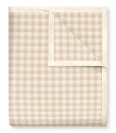 the beige and white checkered blanket is folded