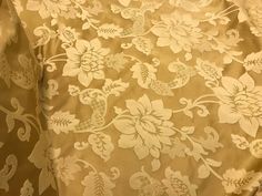 the back of a jacket with flowers and leaves on it, in gold foiled fabric