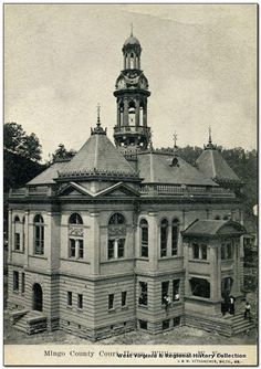 an old black and white photo of a building with a clock on it's tower