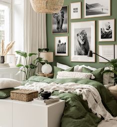 a bedroom with green walls and pictures on the wall above the bed, along with wicker baskets