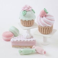 three crocheted cupcakes are sitting on top of each other, one is pink and the other is green