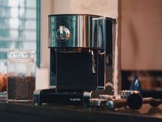 an espresso machine sitting on top of a counter next to some coffee beans