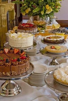 a table topped with lots of cakes and desserts