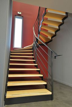 Vue sur l'escalier balancé avec limons double crémaillère, structure acier et marches bois.