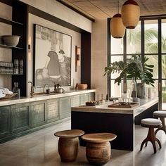 a kitchen with two stools and an island in front of the window, next to a potted plant