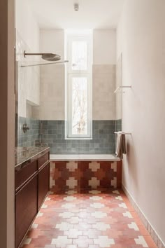 a bathroom with tiled flooring and walls in the shower area, next to a window