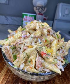 a bowl filled with pasta salad on top of a wooden table