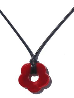 a red heart shaped pendant on a black cord