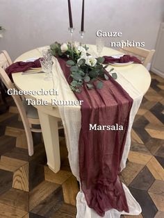 the table is set with two candles and flowers on it, along with other place settings