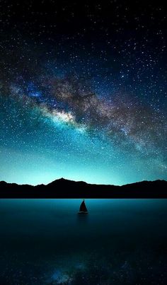 the night sky is filled with stars and milky over mountains, reflecting in calm water