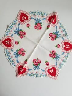 a red and blue heart shaped napkin on top of a white table