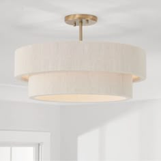 a light fixture hanging from the ceiling in a room with white walls and flooring