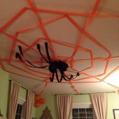 an orange spider web is hanging from the ceiling