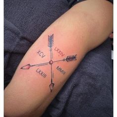 a person with a tattoo on their arm has an arrow and arrows in the middle