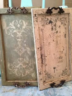 two old framed pictures sitting on top of a table