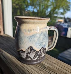 a ceramic mug sitting on top of a wooden table