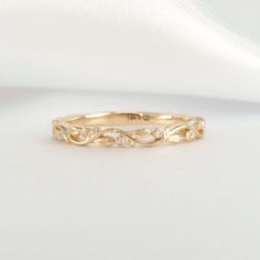 a gold wedding band with diamonds on it