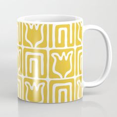 a yellow and white coffee mug with an abstract design