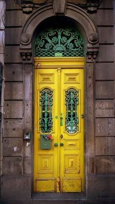 a yellow door with ornate iron work on it