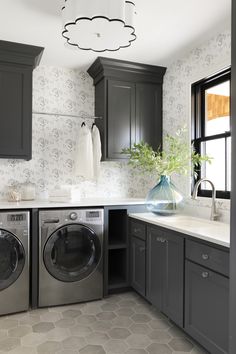 a washer and dryer in a kitchen with dark cabinets, white counter tops