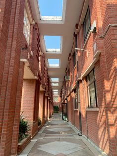 an empty walkway between two buildings with skylights on the top and bottom floor,